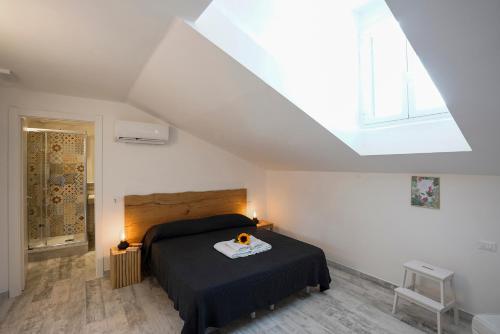 una camera da letto con un letto con una coperta nera e una finestra di Approdo 36 a La Spezia