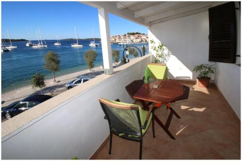 a balcony with a table and chairs and a view of the water at Apartment Slavko in Primošten