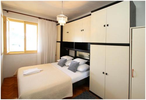 Schlafzimmer mit einem Bett und weißen Schränken in der Unterkunft Apartment Slavko in Primošten