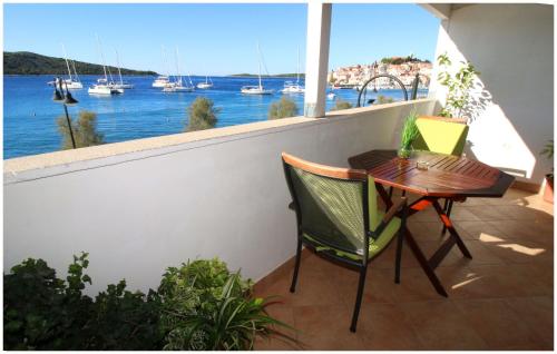 a table and chairs on a balcony with a view of the water at Apartment Slavko in Primošten