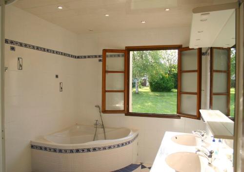 a bathroom with a tub and a sink and a window at St Josse Farmhouse - Nr Le Touquet in Saint-Josse