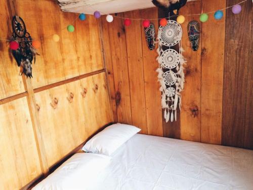 eine Ecke eines Zimmers mit einem Bett in einem Zimmer mit einer Wand in der Unterkunft Hogarista Homestay in Kaledupa