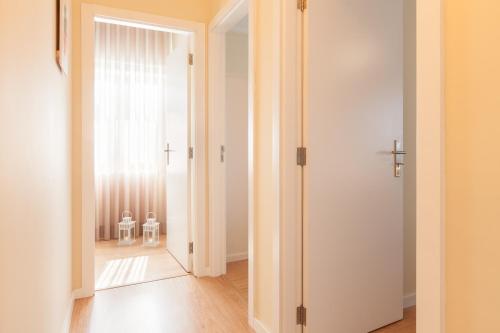 une porte ouverte menant à une chambre avec deux chaises blanches dans l'établissement Feel at home - Free private parking, à Braga