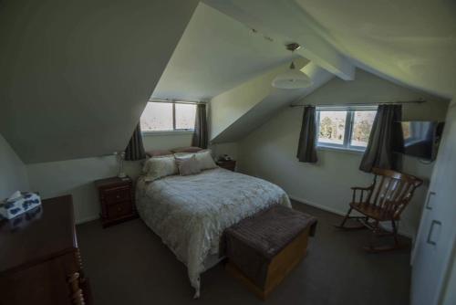 a bedroom with a bed and a chair in a attic at Waipara River Estate in Waipara