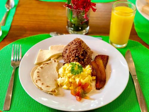 un plato de desayuno con salchichas y tostadas en Arenal Oasis Eco Lodge & Wildlife Refuge, en Fortuna
