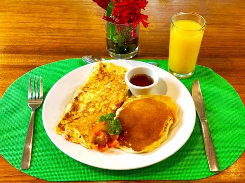 un plato de desayuno con tortillas y un vaso de zumo de naranja en Arenal Oasis Eco Lodge & Wildlife Refuge, en Fortuna