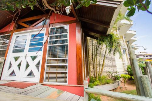 a house with a red and white door at Pousada Lugar ao Sol in Bombinhas