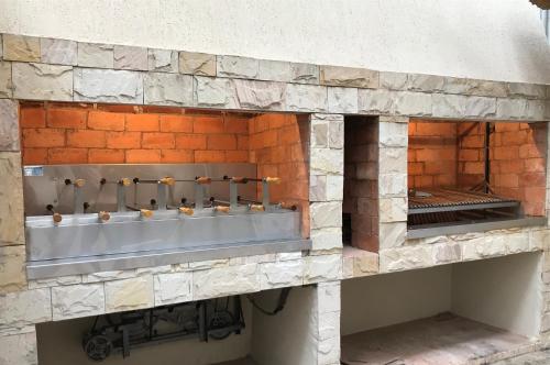pared de piedra con fregadero en un edificio en Del Rio Apart Hotel, en Encarnación