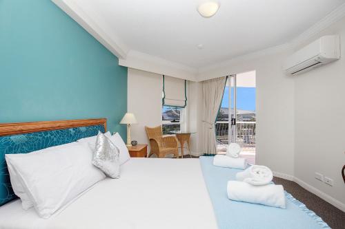 a bedroom with a white bed and a blue wall at Broadbeach in Gold Coast