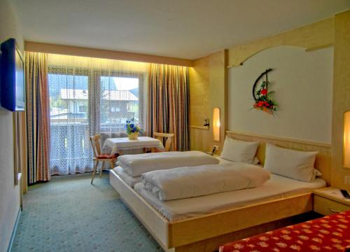 ein Hotelzimmer mit einem großen Bett und einem Tisch in der Unterkunft Haus Marita in Oetz
