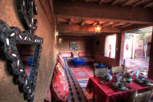 a dining room with a table and a mirror at Jardin de la source in Aït Yous