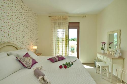a bedroom with a white bed with flowers on it at Elafonisos Resort in Elafonisos