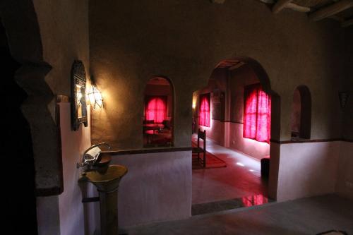 a room with red lighted windows in a building at Jardin de la source in Aït Yous