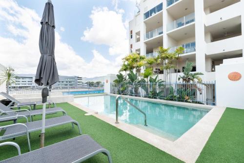 a swimming pool with a lawn chair in front of it at Cairns City Apartments in Cairns