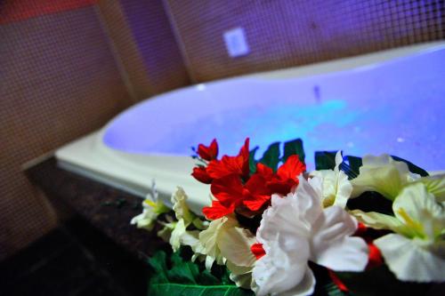 a bouquet of flowers sitting next to a bath tub at HOTEL MYTH-S -ホテル マイス エス- adult only in Sakaide