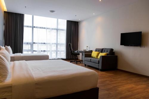 a hotel room with a bed and a desk at Imperial Regency Suites & Petaling Jaya in Kuala Lumpur