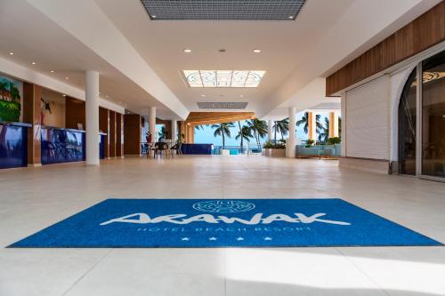a lobby with a blue rug on the floor at Hotel Arawak Beach Resort in Le Gosier