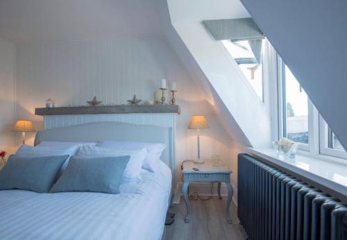 a bedroom with a white bed and a window at The Loft Midhurst in Midhurst