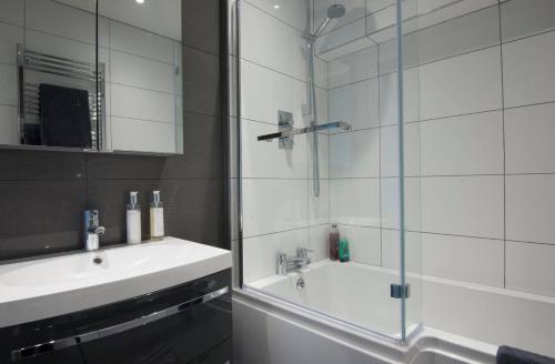 a bathroom with a shower and a sink and a tub at The Loft Midhurst in Midhurst