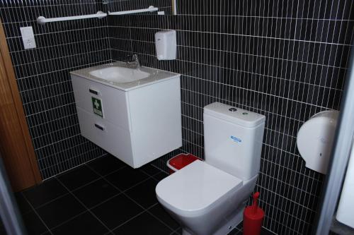 a bathroom with a toilet and a sink at Vila Centro in Vila Franca do Campo
