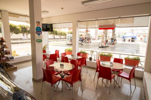 um restaurante com cadeiras e mesas vermelhas e uma janela em El Puerto Hotel em Pacasmayo