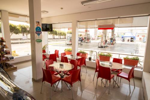 restauracja z czerwonymi krzesłami i stołami oraz oknem w obiekcie El Puerto Hotel w mieście Pacasmayo