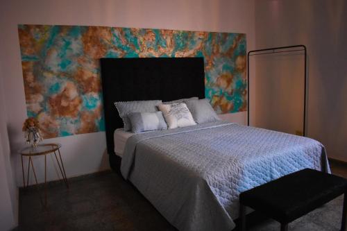 聖塔安娜的住宿－Hostal Sole，一间卧室配有一张壁画床