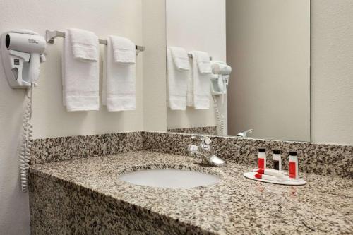 encimera con lavabo y espejo en Travelodge by Wyndham Dunsmuir, en Dunsmuir