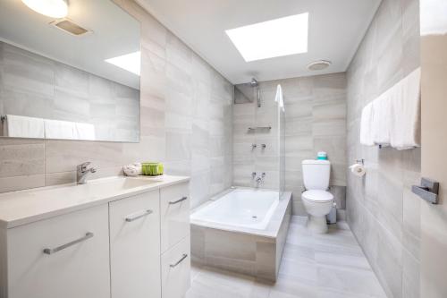 a white bathroom with a toilet and a sink at Nightcap at Coolaroo Hotel in Coolaroo