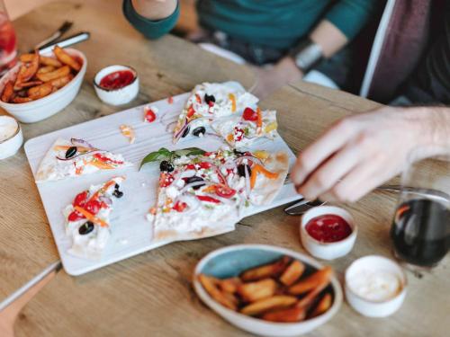 a table topped with food and a plate of fries at ibis Issy les Moulineaux "Val de Seine" in Issy-les-Moulineaux