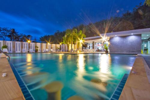a swimming pool in a resort at night at Maikhao Home Garden Bungalow in Mai Khao Beach