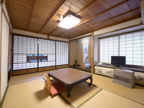 a room with a table in a room with windows at Shokinkan in Yasugi