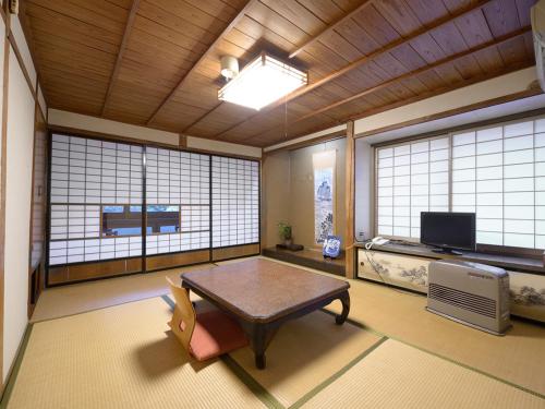 pokój ze stołem w pokoju z oknami w obiekcie Shokinkan w mieście Yasugi