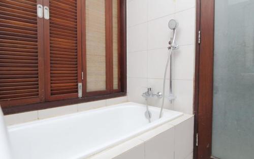 a bathroom with a shower and a bath tub at Suris Boutique Hotel in Kuta