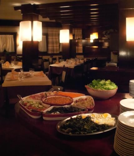 a table with several plates of food on it at Hotel Paladin in San Martino di Castrozza