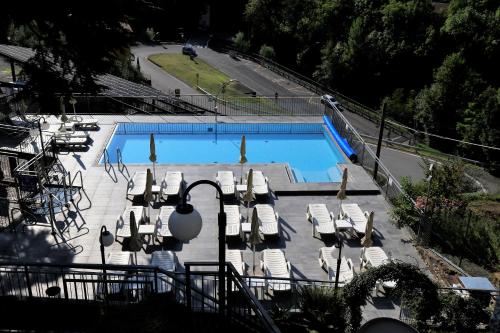 a swimming pool with lounge chairs at Hotel Oasi Verde in Bienno