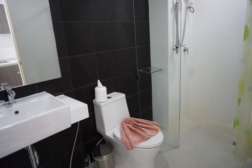 a bathroom with a toilet and a sink and a shower at Ozone Condotel by Thawinan in Kata Beach