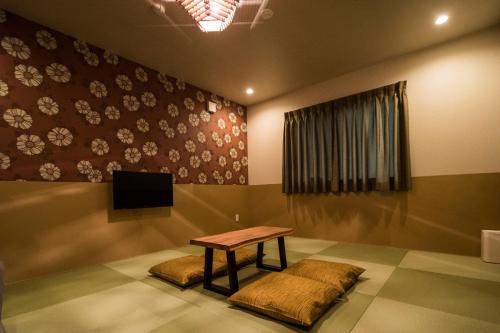 a room with a table and a tv on a wall at KYOSTAY Iroha Komichi in Kyoto