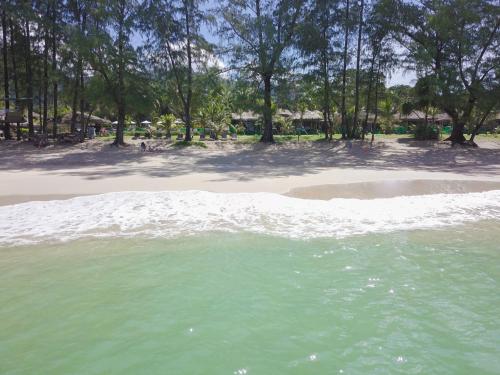 a body of water with a beach and trees at Long Beach Chalet - SHA Extra Plus in Ko Lanta