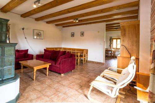 a living room with a red couch and a table at Holiday Villa Stupna in Vidochov