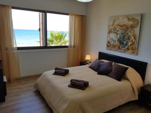 ein Schlafzimmer mit einem großen Bett mit zwei Handtüchern darauf in der Unterkunft Haig's Dream Flat On The Beach in Larnaka