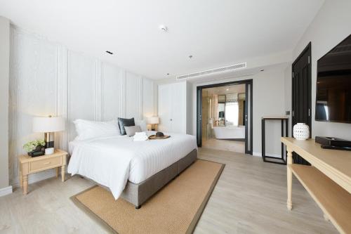 a bedroom with a white bed and a bathroom at Health Land Resort & Spa in Pattaya South