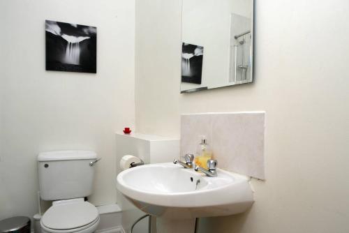 a bathroom with a white toilet and a sink at Grindlay Street Residence, 2 Bedroom, 2 Bathroom apartment close to Castle in Edinburgh
