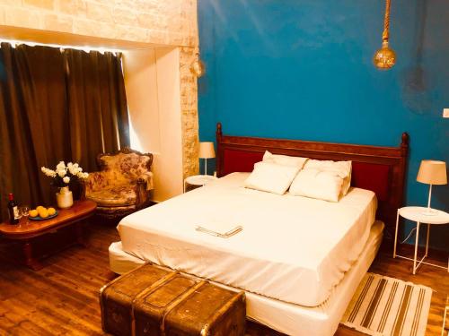 sypialnia z łóżkiem i niebieską ścianą w obiekcie Karavella Vintage Apartment w Pafos