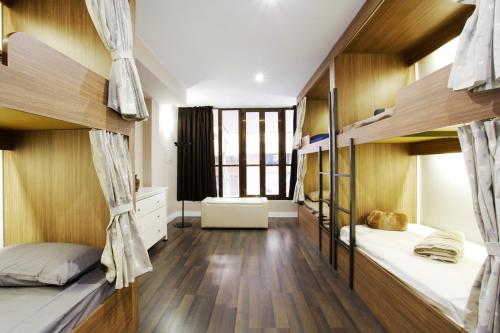 a dorm room with two bunk beds and wooden walls at Barcelona & You Hostel Sagrada Familia in Barcelona