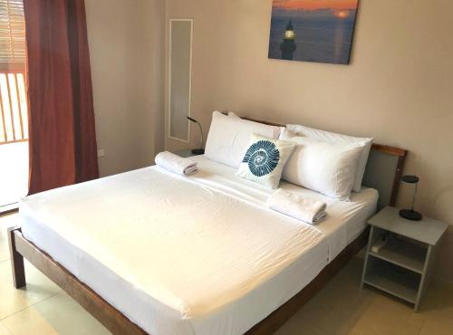 a bedroom with a large bed with white sheets and pillows at Reef Beach Resort in General Luna