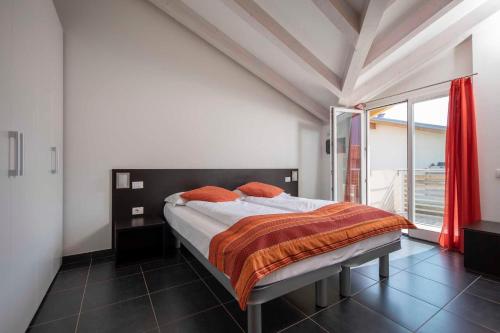 a bedroom with a bed and a large window at 4 Limoni Apartment Resort in Riva del Garda