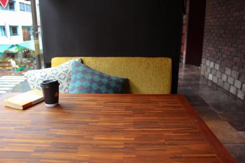 a cup of coffee sitting on a table with a pillow at HARE-TABI SAUNA & INN Yokohama - ハレタビ - in Yokohama