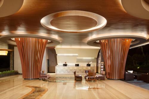 a lobby with tables and chairs and domed ceilings at Hotel Santika Banyuwangi in Banyuwangi