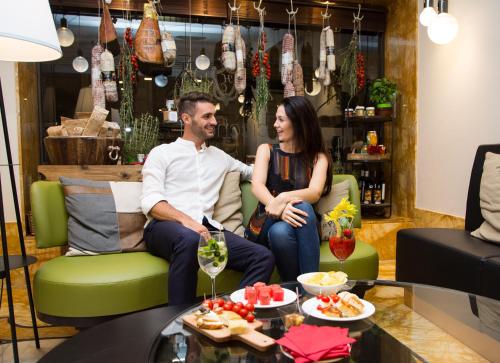 a man and woman sitting on a couch in a living room at BW Premier Collection CHC Continental in Venice